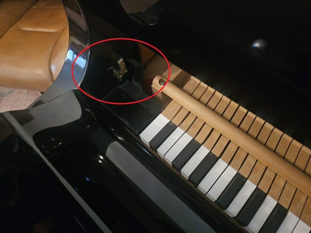 A fallboard being removed from a grand piano.