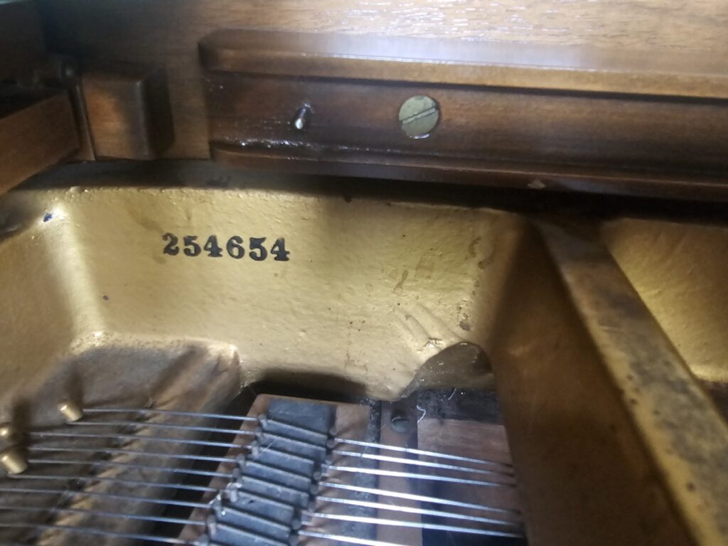 Close up of the serial number on a Howard grand piano.