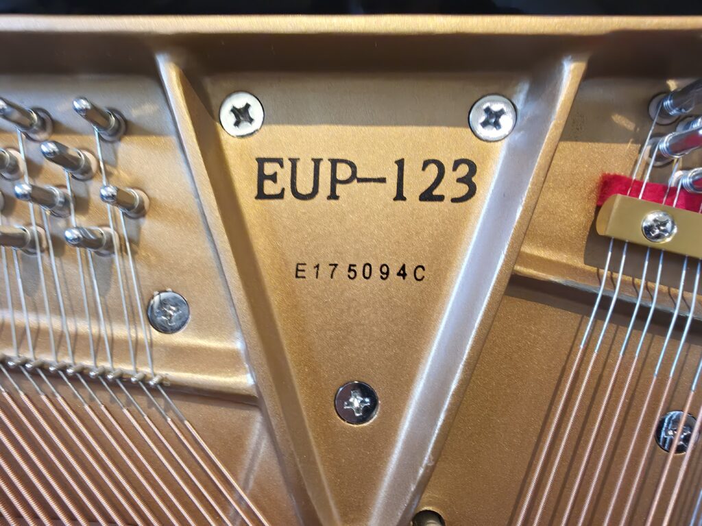 Close-up of the serial number and model number on an Essex upright piano.
