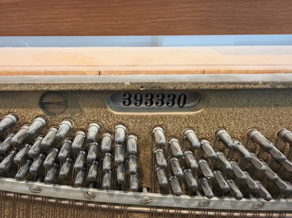 A close-up of the serial number on a Cable spinet piano.