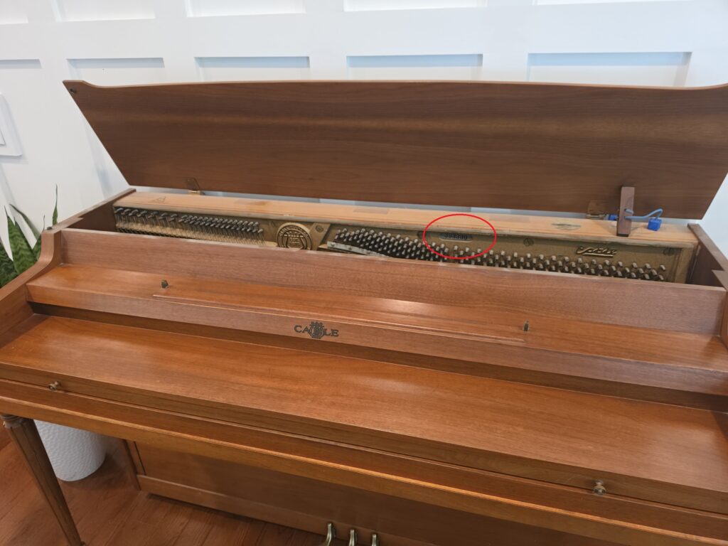 A Cable spinet piano with it's lid open.