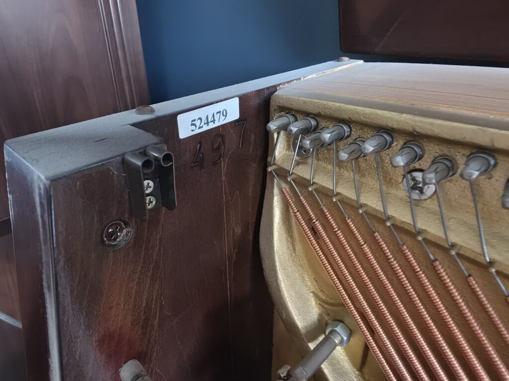 A close up of the location of the serial number on a Charles Walter upright piano.