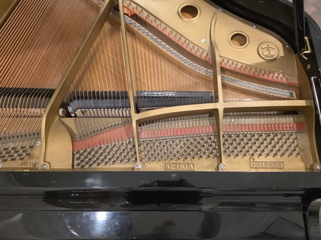 Hyundai grand piano with the lid open and the music rack removed.