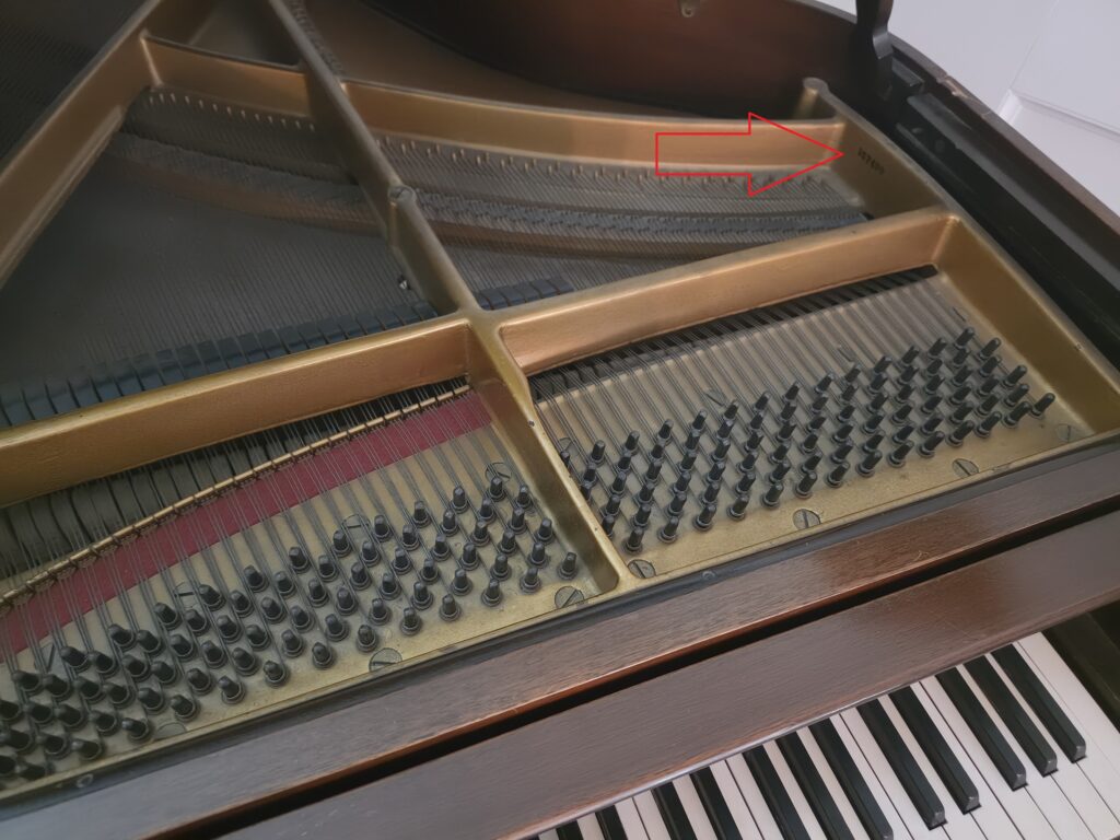 A Monarch grand piano with it's lid open and music rack removed.