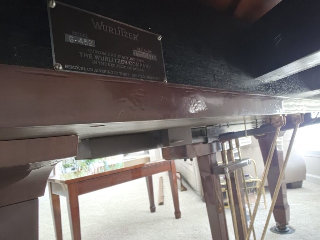 Serial number badge on a Wurlitzer grand piano.