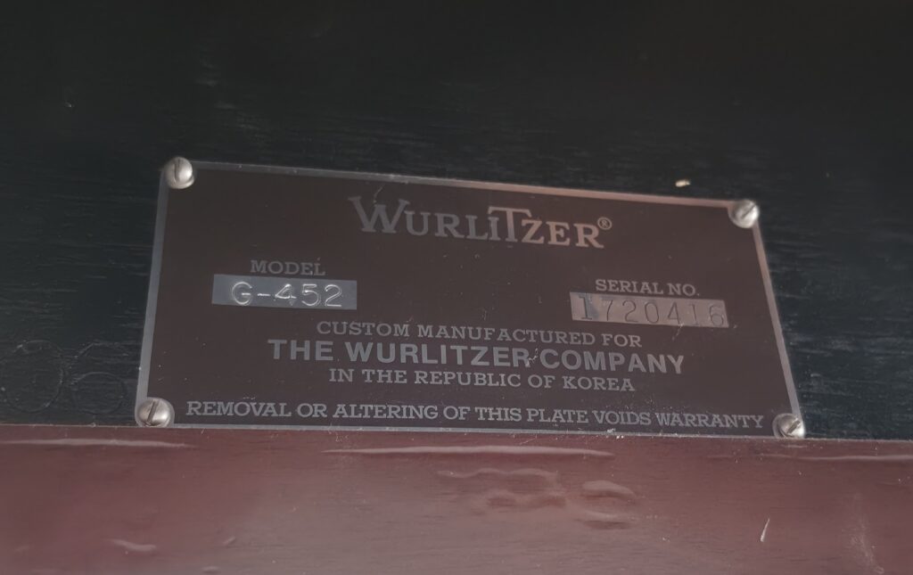 Wurlitzer grand serial number badge close-up.