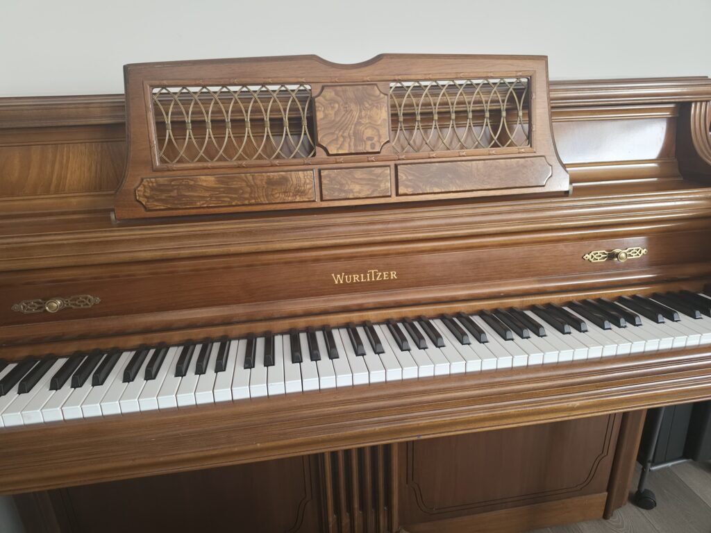 A Wurlitzer studio piano shown from the front.