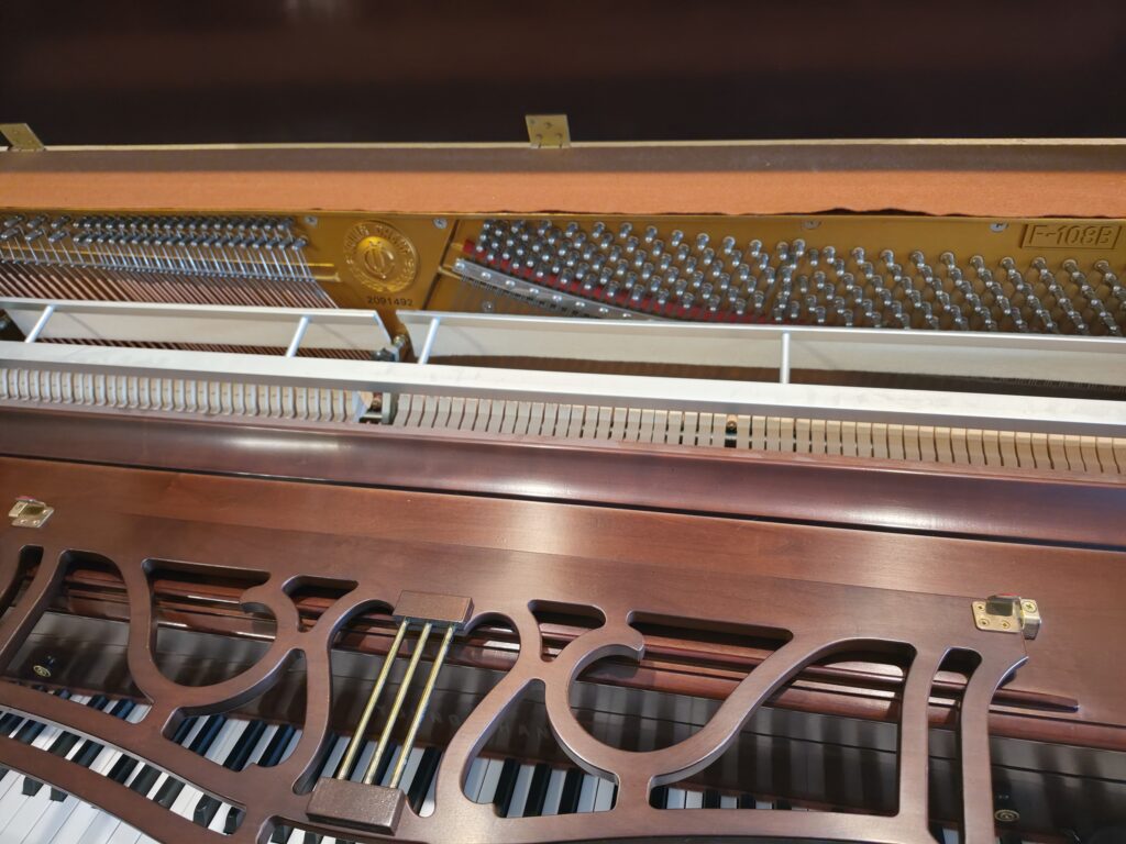 A Young Change studio piano with it's lid open.