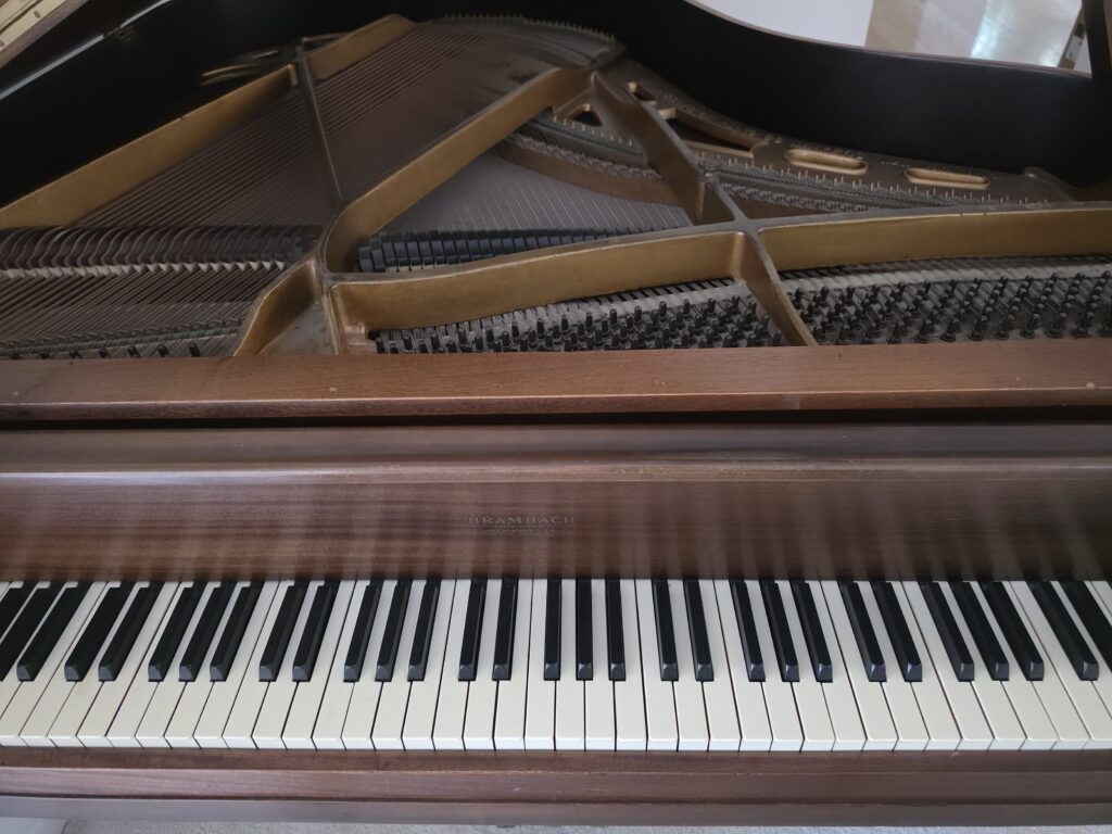 A Brambach grand piano with the lid open.