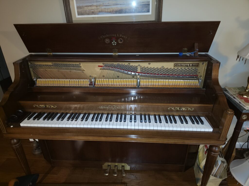 A modern Chickering upright with the lid open.