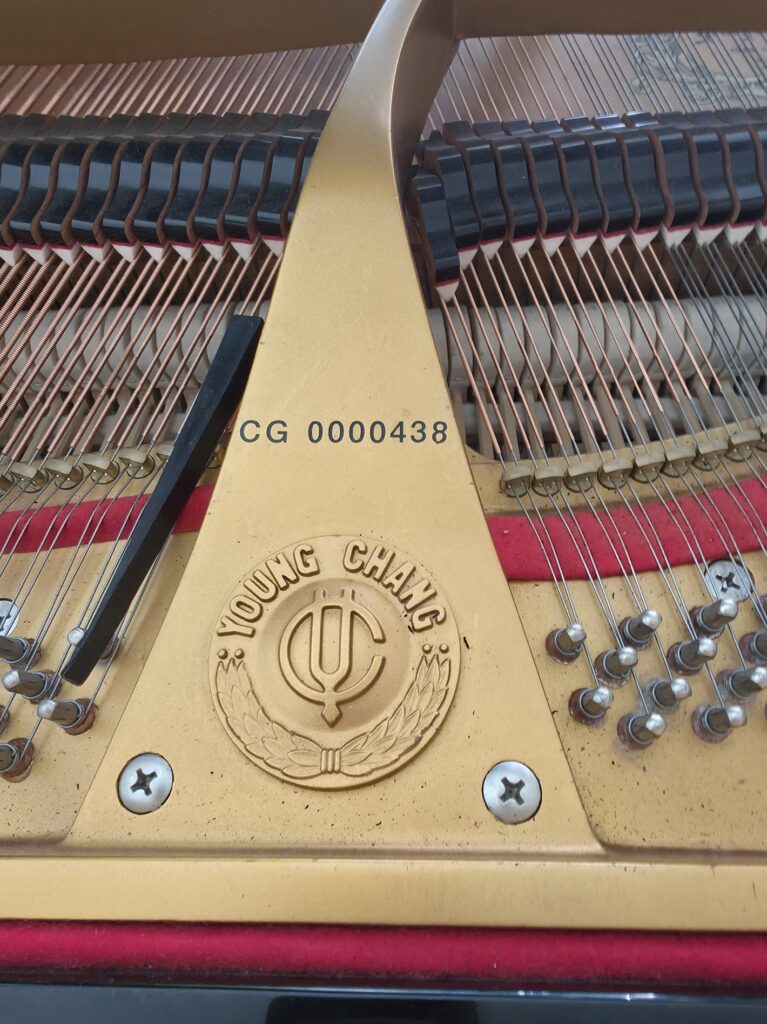 A close-up of the serial number on a Young Chang grand piano.